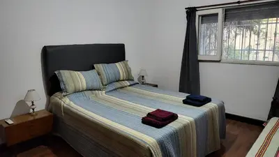 a bedroom with a bed with two bags on it at Amplia casa cerca del centro de la ciudad in Cordoba