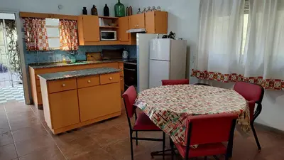 a kitchen with a table and a white refrigerator at Amplia casa cerca del centro de la ciudad in Cordoba