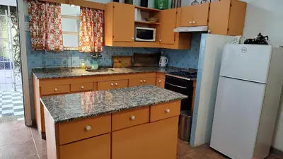 a kitchen with wooden cabinets and a white refrigerator at Amplia casa cerca del centro de la ciudad in Cordoba