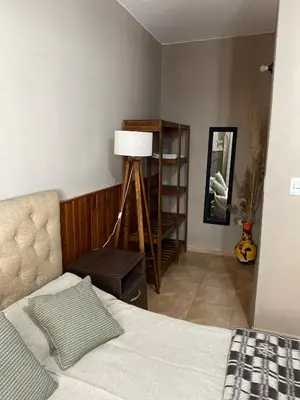a bedroom with a bed and a lamp and a shelf at La moora in Alta Gracia