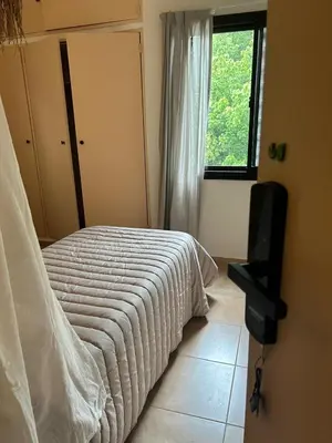 a bedroom with a bed and a television and a window at Casa Frida - Alojamiento exclusivo para Mujeres - in Villa Carlos Paz
