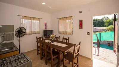 a kitchen and dining room with a table and chairs at Cabaña El Candil Solo Familias in Villa Carlos Paz