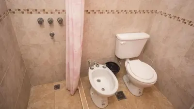 a bathroom with a toilet and a shower at Cabaña El Candil Solo Familias in Villa Carlos Paz