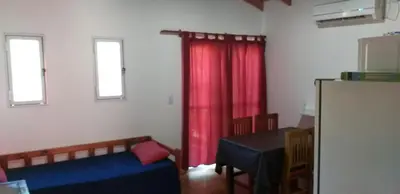 a room with a bed and a red curtain and a table at Los Damascos in Merlo