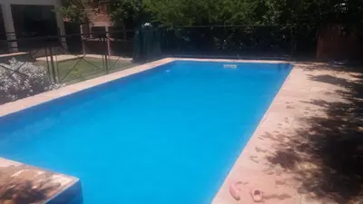 a swimming pool with blue water in a yard at Los Damascos in Merlo
