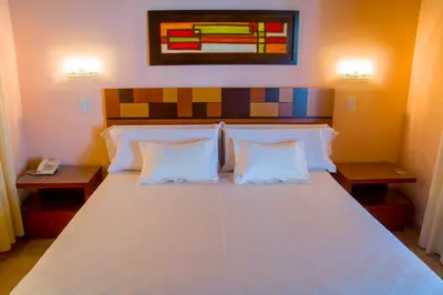 a bedroom with a large white bed with two pillows at Hotel Parque in Merlo