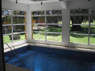 a swimming pool in a room with windows at Hotel Parque in Merlo