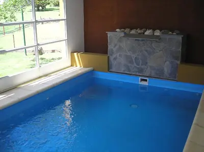 a swimming pool in a room with a window at Hotel Parque in Merlo