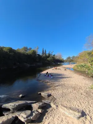 a group of people on a beach next to a river at Los Condores in La Bolsa