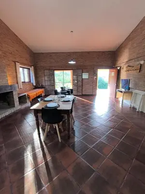 a large living room with a table and a fireplace at Los Condores in La Bolsa