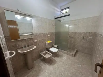 a bathroom with a toilet and a sink and a shower at Luluara in Villa Carlos Paz