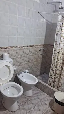 a bathroom with a toilet and a sink and a shower at Luluara in Villa Carlos Paz