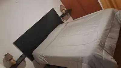 a bedroom with a bed with a white bedspread at Luluara in Villa Carlos Paz