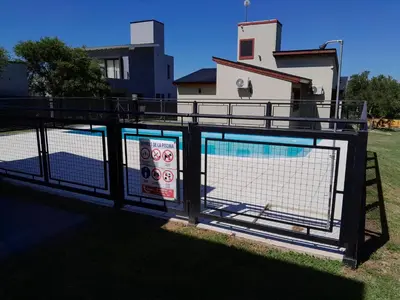 a fence with two signs on it in front of a building at Complejo de Cabañas Los Virreyes in Cerro de Oro