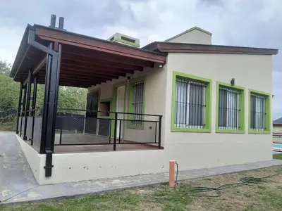 a house with a balcony with a gate at Complejo de Cabañas Los Virreyes in Cerro de Oro