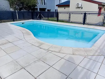 a swimming pool with blue water in a yard at Complejo de Cabañas Los Virreyes in Cerro de Oro