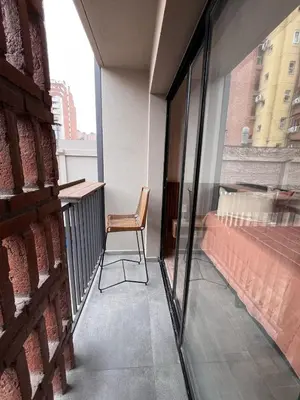 a balcony with a chair and a bed in a building at Guarida Güemes in Cordoba