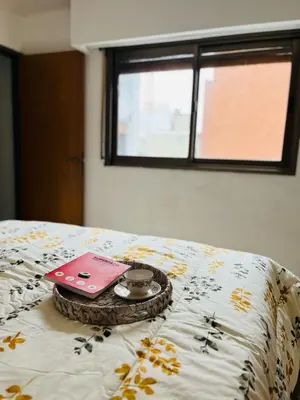 a bed with a tray with a clock on it at AMOBLADOS CORDOBA - Centro Histórico in Cordoba