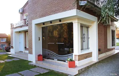 a brick house with a large glass door on it at Posada de las Sierras in Merlo