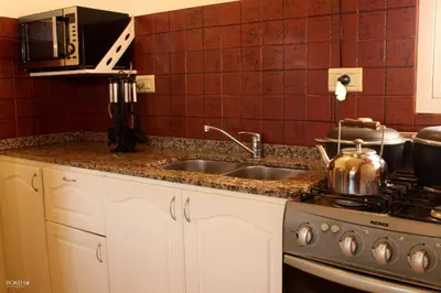 a kitchen with a sink and a stove at Posada de las Sierras in Merlo