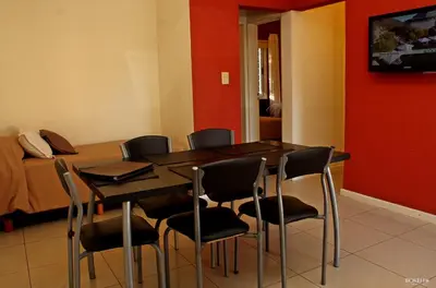 a dining room with a table and chairs and a bed at Posada de las Sierras in Merlo