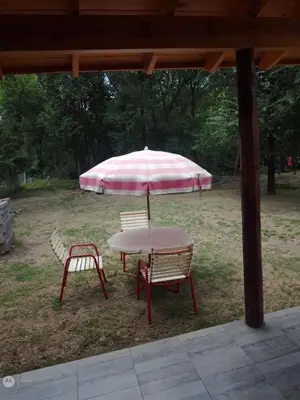 a table and two chairs under a pink umbrella at cabañas neli in Santa Rosa de Calamuchita