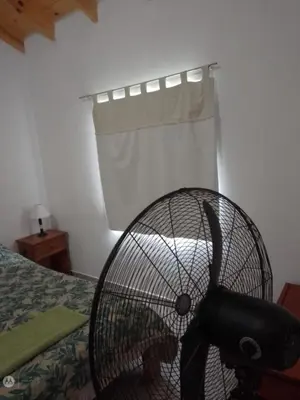 a fan sitting on a bed in a bedroom at cabañas neli in Santa Rosa de Calamuchita