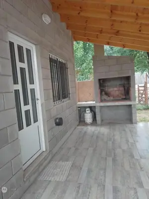 a patio with a brick fireplace and a white door at cabañas neli in Santa Rosa de Calamuchita
