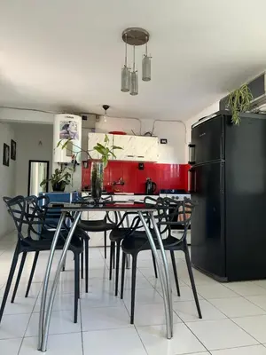 a kitchen with a table with chairs and a refrigerator at Amanecer eterno in Cordoba