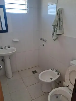 a white bathroom with a toilet and a sink at Departamento para 2 personas in Alta Gracia