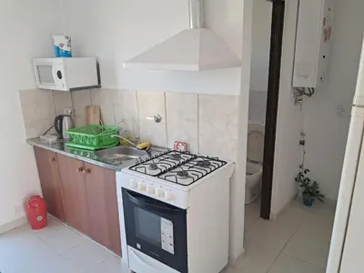 a kitchen with a white stove and a sink at Departamento para 2 personas in Alta Gracia