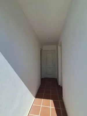 an empty hallway with a door and a tile floor at Departamento para 2 personas in Alta Gracia
