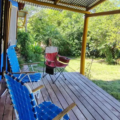 a porch with two chairs and a table and a rocking chair at La Casa Azul in San Javier