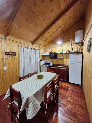 a kitchen with a table with chairs and a refrigerator at Rincon Soñado in La Porteña