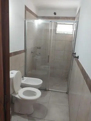 a bathroom with a toilet and a glass shower at Mate host 2 in Cordoba