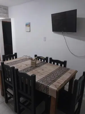 a wooden table with chairs and a television on a wall at Mate host 2 in Cordoba