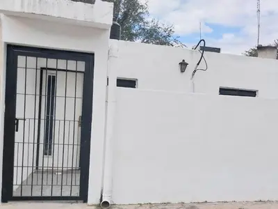 a white building with a gate on the side of it at Mate host 2 in Cordoba