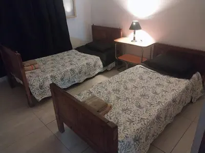 a room with three beds and a table and a lamp at Mate host 2 in Cordoba