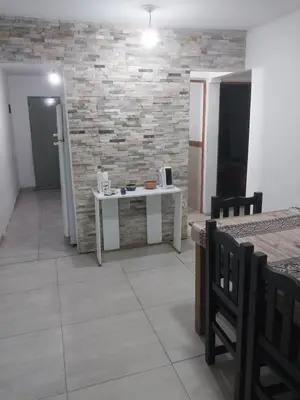 a room with a table and a stone wall at Mate host 2 in Cordoba