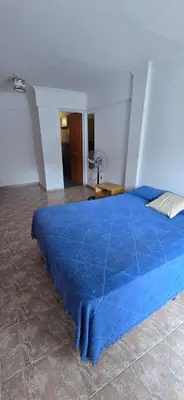 a blue bed with a blue comforter in a room at La Martina in Villa Carlos Paz