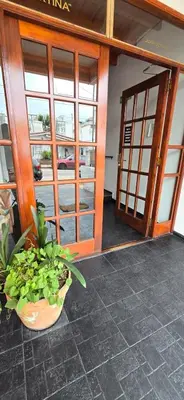 an open door of a building with a potted plant at La Martina in Villa Carlos Paz