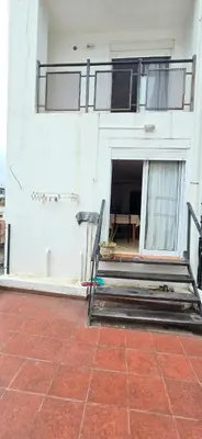 a building with a patio with a table and a balcony at La Martina in Villa Carlos Paz
