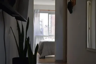 a room with a bed and a window with a plant at Departamento Abril in Cordoba