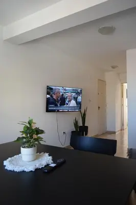 a room with a table with a tv on the wall at Departamento Abril in Cordoba