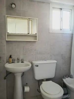 a bathroom with a white toilet and a sink at Departamento Abril in Cordoba
