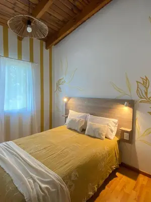 a bedroom with a large bed with a yellow blanket at Casa Manantiales in Villa General Belgrano