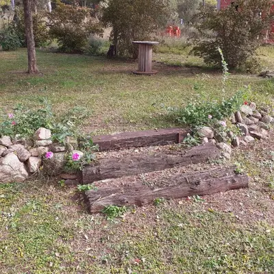 a wooden bench sitting in a field with flowers at Casa Manantiales in Villa General Belgrano