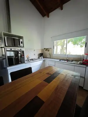 a kitchen with a large wooden table and a large window at Casa Manantiales in Villa General Belgrano