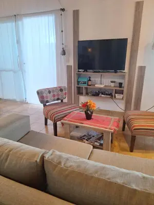 a living room with a couch and a flat screen tv at Casa Manantiales in Villa General Belgrano