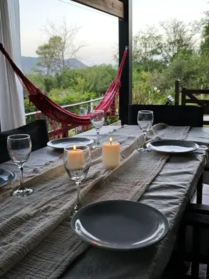 a wooden table with a candle and plates and glasses at Casa Manantiales in Villa General Belgrano